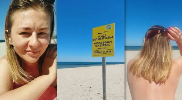 Uśmiechnięta kobieta na plaży nudystów. Obok tablica informująca o obszarze.