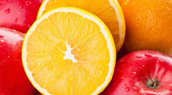 Soczyste pomarańcze i jabłka, idealne na zdrową dietę i odchudzanie. Kropla wody na skórce jabłka.