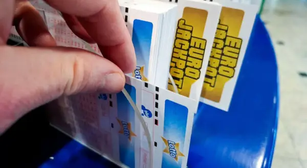 Dłoń wybiera kupony Eurojackpot. Dlaczego w Eurojackpot trudniej trafić siódemkę niż szóstkę w zwykłym Lotto? Więcej liczb do wyboru!