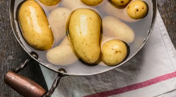 Kleine, gelbe Kartoffeln in einem Topf mit Wasser, bereit zum Kochen. So einfach ist es, Kartoffeln zuzubereiten!