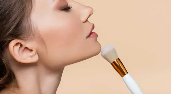 Primo piano del viso di una donna con pennello da trucco. La cipria traslucida dona un finish naturale e opacizzante, il suo significato è perfezione.
