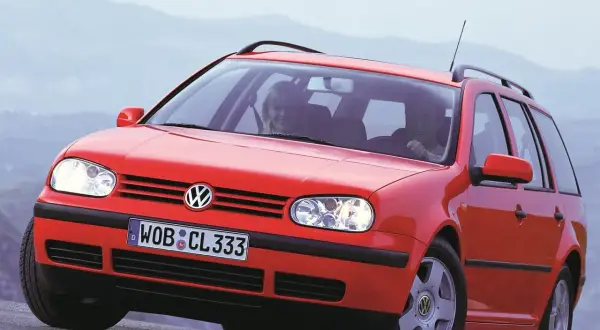 Czerwony Volkswagen Golf 4 Variant z uśmiechniętymi pasażerami. Widać przednie światła i grill, ale nie ma tu golf 4 żarówki tylne.