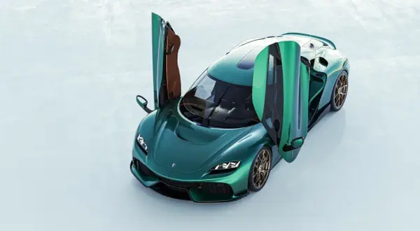 Zielony Koenigsegg Gemera z otwartymi drzwiami, gotowy do podróży.