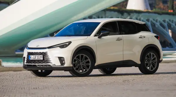 Biały Lexus LBX na tle nowoczesnej architektury. Sprawdź jego lexus lbx dane techniczne i odkryj możliwości tego miejskiego SUV-a.