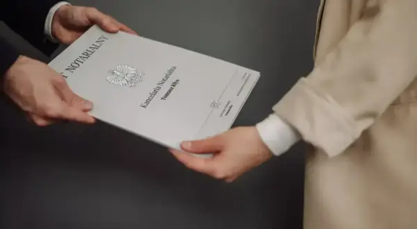 Wręczenie dokumentu "Akt poświadczenia dziedziczenia" w kancelarii notarialnej.