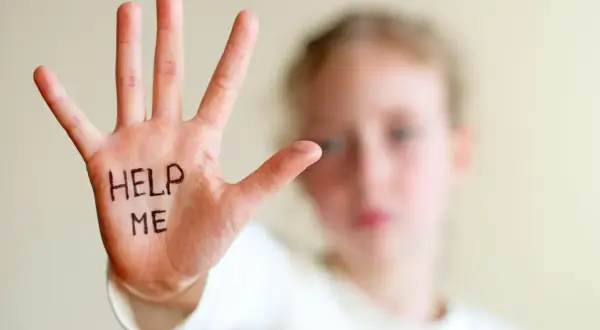 Dłoń dziecka z napisem "HELP ME" symbolizuje trudności, z jakimi mogą borykać się osoby z zespołem hiperkinetycznym, potrzebujące wsparcia.
