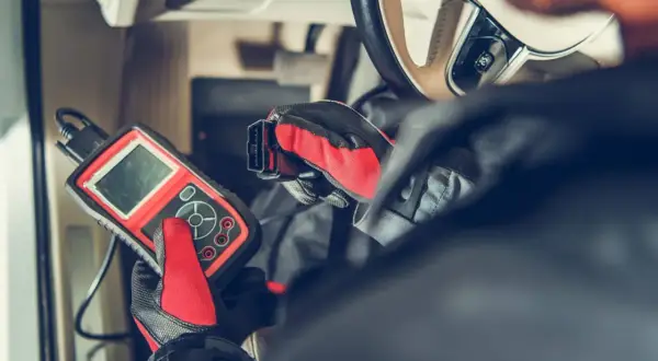 Mechanik diagnozuje problem z czujnikiem ABS w Astrze H, używając skanera diagnostycznego.
