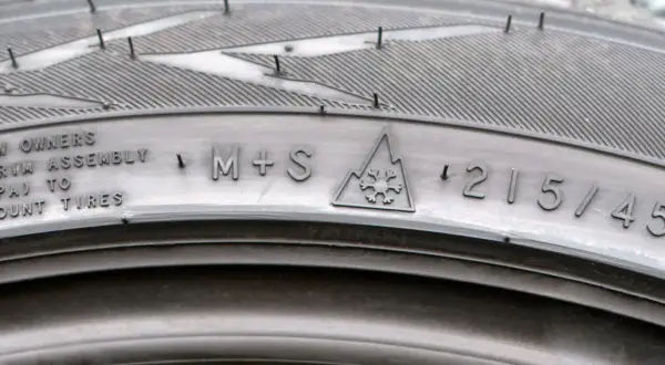 Opona zimowa z oznaczeniem M+S i symbolem płatka śniegu w górach. Rozmiar 215/45. Idealna na 3pmsf.