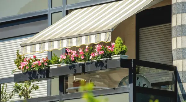 Jak zrobić daszek na balkon? Ten markiza z kwiatami to inspiracja.