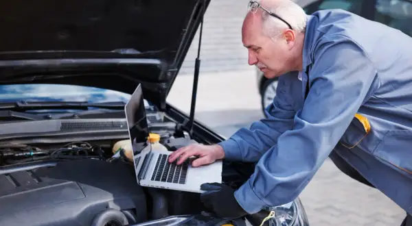 Mechanik diagnozuje awarię pojazdu Opel Astra J za pomocą laptopa. Skontaktuj się z serwisem Opel Astra J w razie problemów.