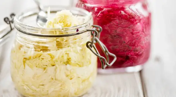 Två glasburkar med surkål, en ljus och en röd. Perfekt för ditt surkål recept!