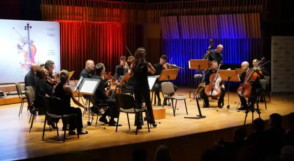 Orkiestra symfoniczna gra na scenie. W tle czerwone i niebieskie światła. Wspaniały radom koncert dzisiaj!
