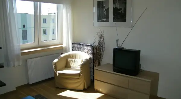 Stary telewizor i fotele, pamiątka po dziadkach, symbolizują dziedziczenie.