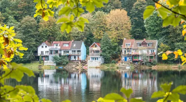 Jesienne domy nad jeziorem na Dolnym Śląsku, odbijające się w spokojnej wodzie.