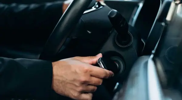 Mano insertando la llave para la puesta en marcha del coche.