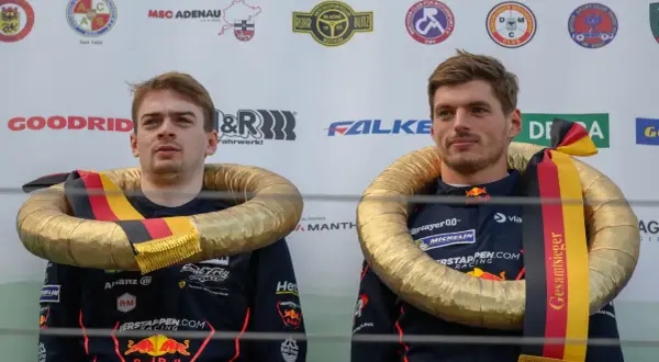 Max Verstappen celebra su victoria en el Nürburgring con un collar dorado y la bandera alemana.