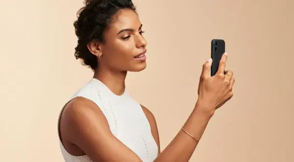 Donna con smartphone, utile per capire come scegliere fondotinta online.