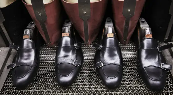 Scarpe marchigiane famose, mocassini neri con doppia fibbia, pronti per la lucidatura.