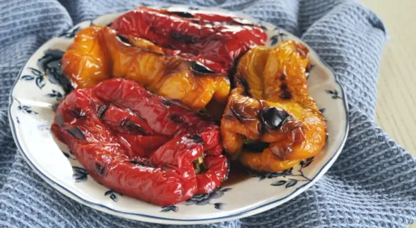 Peperoni rossi e gialli arrostiti, pronti per spellare in forno. Un contorno saporito e colorato.