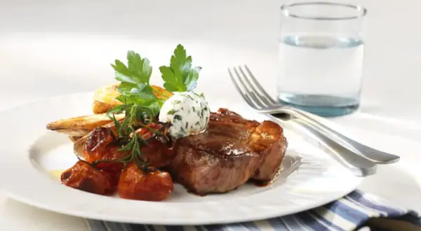 En saftig biff med rostade tomater, potatis och örtsmör. Ett perfekt karre recept för en lyxig middag.
