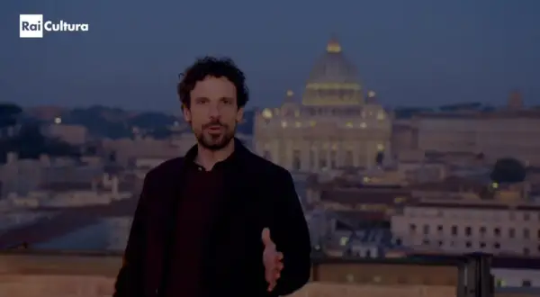 Francesco Montanari, con la sua altezza, parla davanti a San Pietro al tramonto.