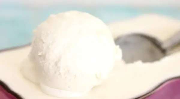 Una bola cremosa de helado de nata Thermomix sobre un plato, lista para ser disfrutada.