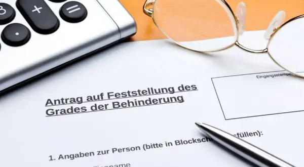 Antrag auf Feststellung des Grades der Behinderung, mit Brille, Taschenrechner und Stift. Wichtig für die Einschätzung des osteochondrose behinderungsgrad.