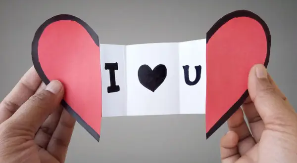 Cuore rosso diviso a metà, con un biglietto che dice "I ♥ U". Un'idea per i san valentino lavoretti fai da te.