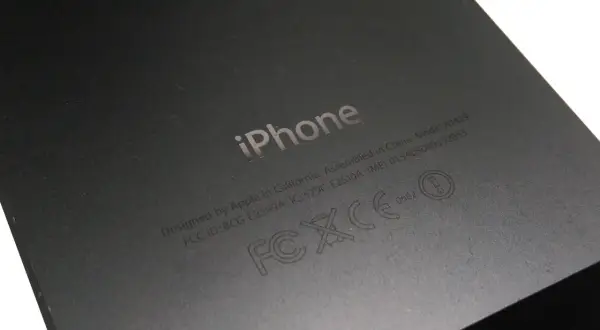 Tył iPhone'a z wygrawerowanym logo i informacjami, w tym numerem IMEI: 013408009192055.