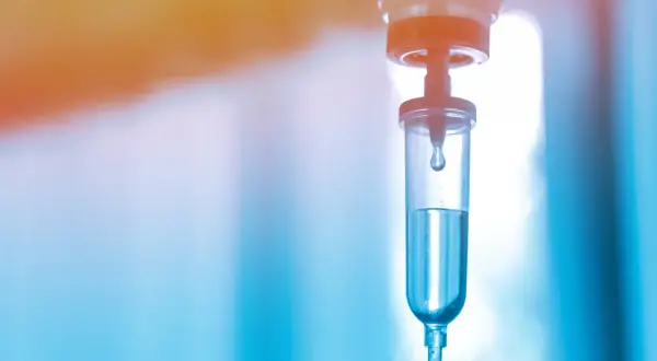 Tropfen für Tropfen fließt die Flüssigkeit in den Tropfbehälter. Ein Hoffnungsschimmer für die Immuntherapie-Infusion.