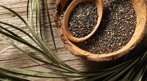 Graines de chia dans un bol en bois, une cuillère en bois remplie. Parfait pour un régime sain et équilibré.