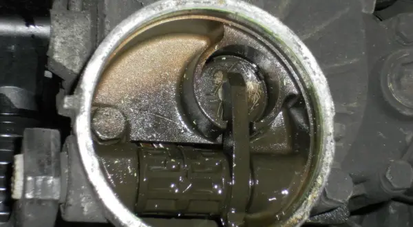 Mécanisme de transmission avec un embrayage bloqué en bas, baignant dans une huile sombre.