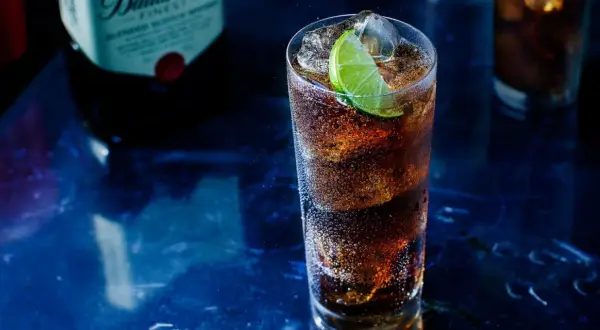 Orzeźwiający drink z whisky i colą, z plasterkiem limonki. Idealny pomysł, z czym pić whisky na wieczór.