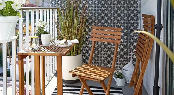 Drewniane meble i wysoka trawa tworzą przytulną atmosferę, idealną, by osłonić balkon od sąsiadów.