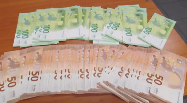 Stosy banknotów 100 i 50 euro na drewnianym stole. Taki widok może towarzyszyć przewozowi gotówki w strefie Schengen.