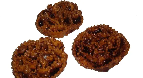 Tre cartellate viestane, dolci tipici pugliesi ricoperti di vincotto, invitano a un assaggio di tradizione.