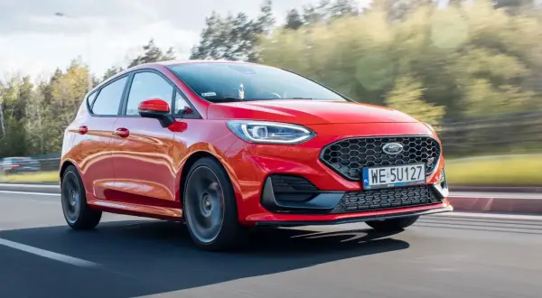 Czerwony Ford Fiesta w ruchu, widoczne felgi i opony. Rozmiar opon jest kluczowy dla osiągów.