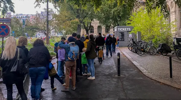 Kolejka do kasy biletowej przy Muzeum Historii Naturalnej w Berlinie. W tle budynek muzeum i drzewa.