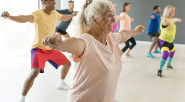 Animation ehpad : des seniors actifs et souriants participent à un cours de danse dynamique, montrant que l'âge n'est pas une barrière à la joie de bouger.