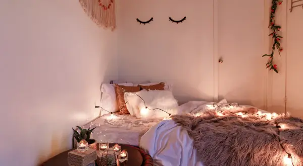 Gemütliches Schlafzimmer mit Lichterkette und Kissen. Tolle geschwister zimmer teilen ideen für eine kuschelige Atmosphäre.