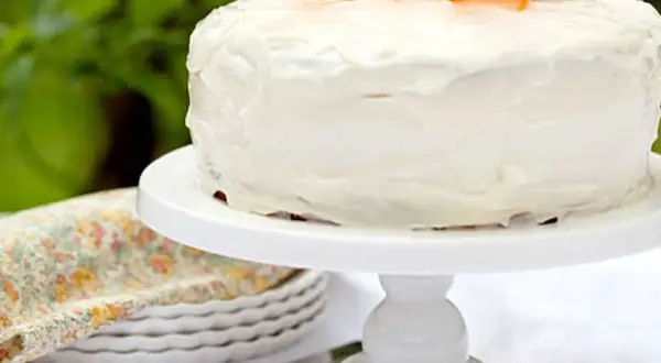En saftig glutenfri morotskaka med vit frosting och strimlade morötter som dekoration. Perfekt för fikat!