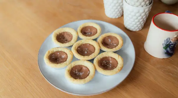 Små chokladbakelser med flingsalt, perfekta för ett dumlekakor recept. Serveras på en ljusblå tallrik.