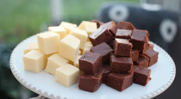 En vit bricka med staplade bitar av ljus och mörk fudge. Perfekt för ett enkelt fudge recept.