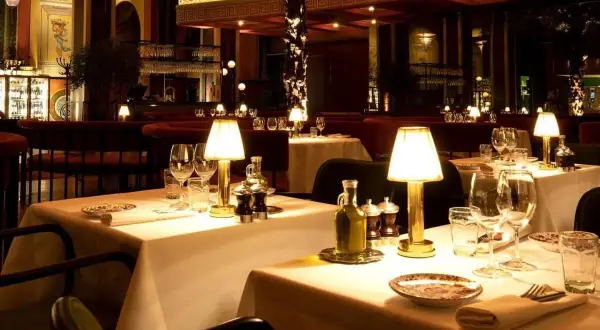 Ett elegant dukat bord med tända lampor, glas och olivolja. En inblick i en av Stockholms trendiga restauranger.