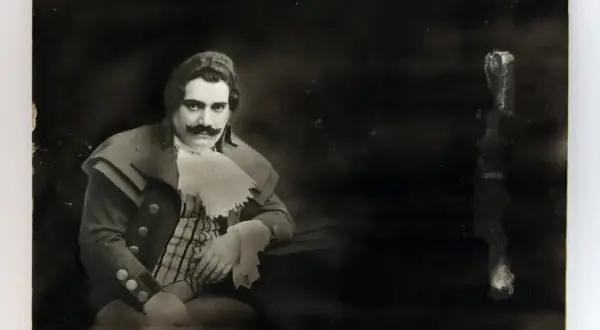 Ritratto di Enrico Caruso, la cui causa morte è ancora oggetto di dibattito. Indossa un costume d'epoca con baffi imponenti.