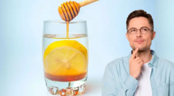 Hombre pensativo junto a un vaso de agua con limón y miel, perfecto para empezar el día.