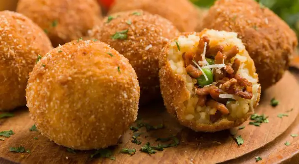 Chrupiące arancini, pyszne włoskie dania mięsne, z bogatym nadzieniem mięsnym i groszkiem, posypane parmezanem.