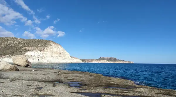 Costa rocosa y mar azul en la cala cortada Almería. El sol ilumina las formaciones rocosas y el agua cristalina.