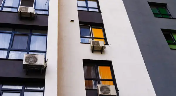 Klimatyzacja w bloku, zamontowana na ścianie z oknami, zapewnia komfortowe warunki.