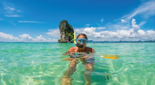Kobieta w masce do snorkelingu pływa w turkusowej wodzie. Czy Tajlandia jest bezpieczna? Tak, to raj dla turystów!